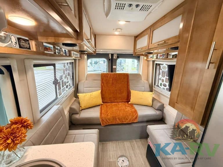 Cozy RV living area with sofa, pillows, and windows.