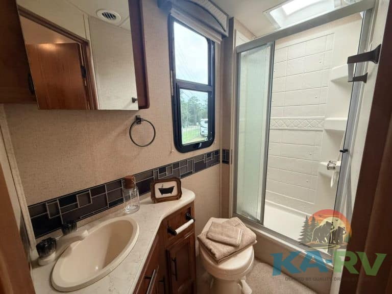 RV bathroom with shower, sink, and window at Karv Repair.