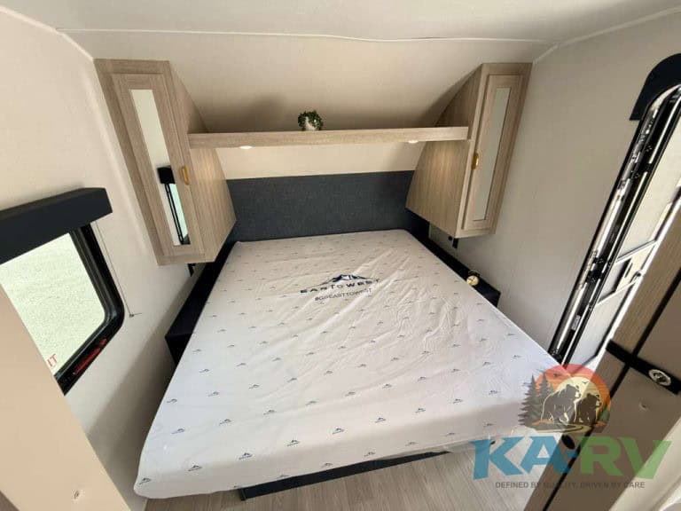Interior view of 2026 Acclaim 2500RD RV with bed and storage cabinets.