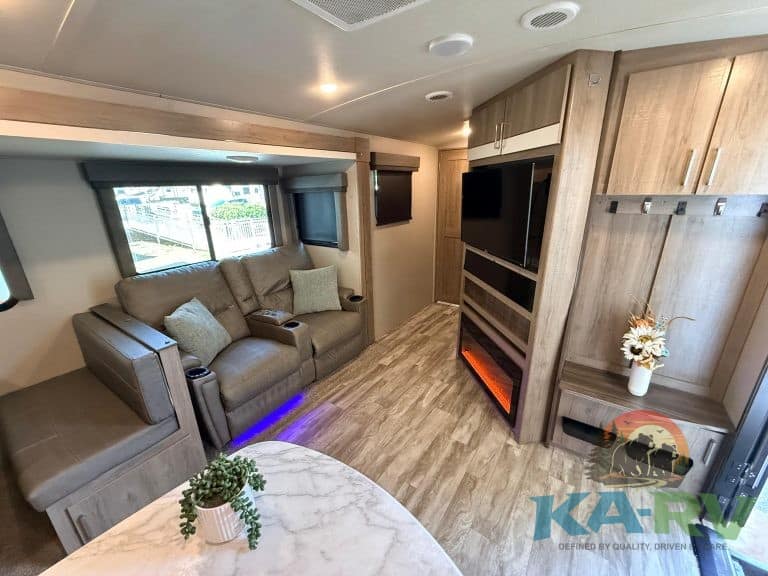 RV interior living room featuring a sofa, fireplace, and modern cabinetry for comfort and style.