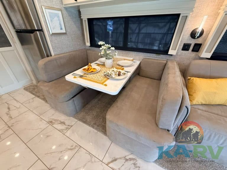 Luxury RV interior with dining area and plush seating in Tiffin Allegro Bay 38AB.