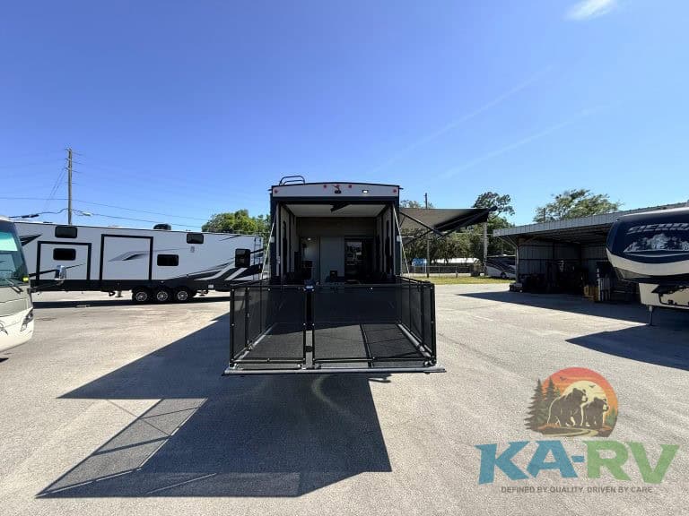 Optima RV trailer with outdoor living space and fold-down ramp.