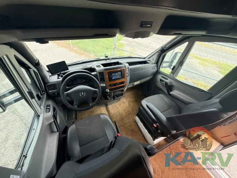 Interior view of a Mercedes-Benz RV dashboard and seating area.