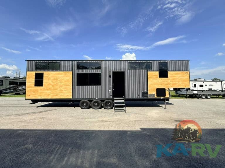 Cedar Creek Cottage 41 FWC with black and wood exterior, on a trailer.