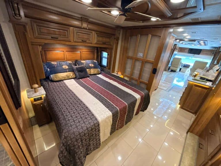 Luxury RV bedroom with wooden cabinetry and plush bedding in a 2016 Entegra Cornerstone 45B.