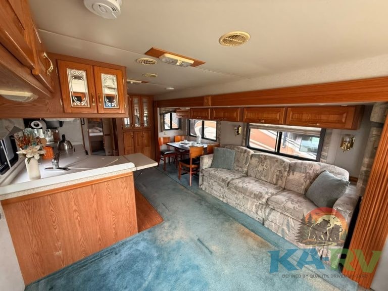 RV interior with wooden cabinetry and a sofa, showcasing a cozy living space.