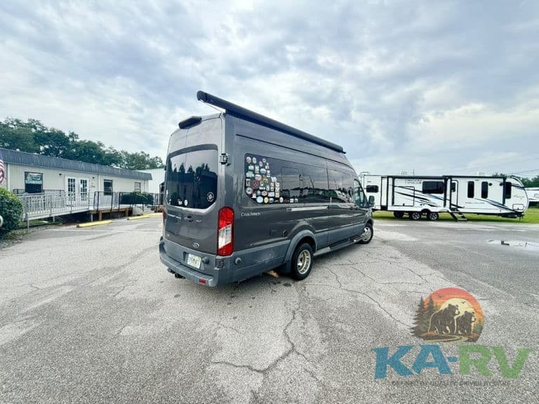 Black custom RV conversion van parked at RV dealership lot.