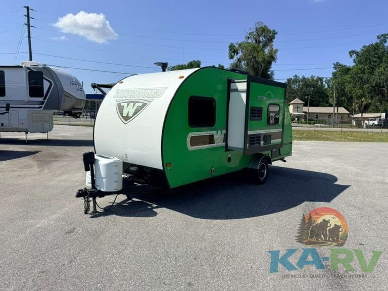 Green and white Winnebago Winnie Drop 1780 travel trailer on lot.