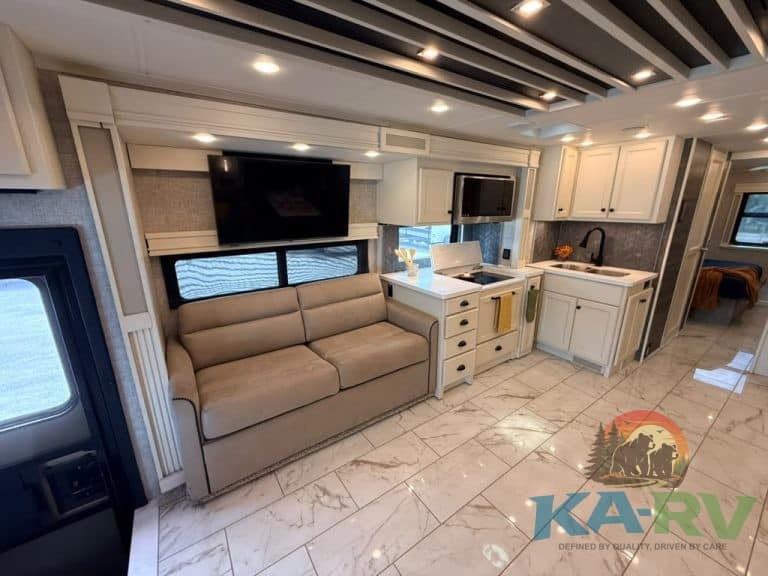 Modern RV interior with sofa, kitchen, and entertainment area in Tiffin Allegro Bay 38AB.