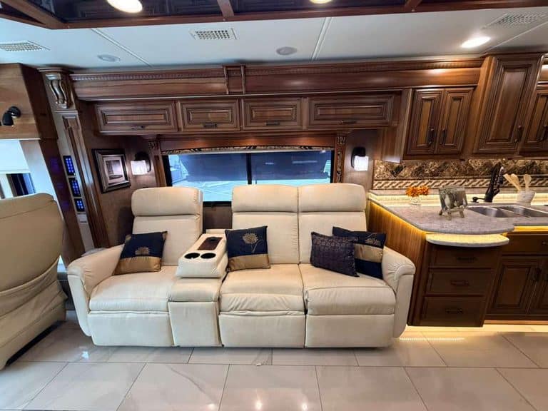 Luxury RV interior with cream sofa and wooden cabinetry in a 2016 Entegra Cornerstone 45B.