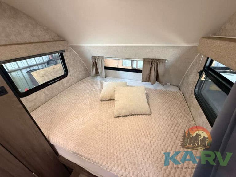 Cozy RV bedroom with windows and bedding for Winnebago Winnie Drop 1780.