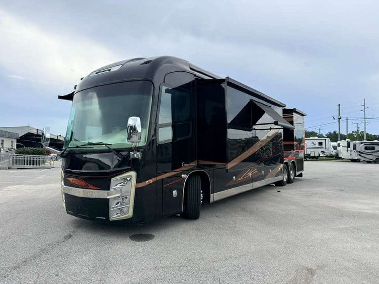 Black luxury RV with slide-outs at KA RV Repair lot.