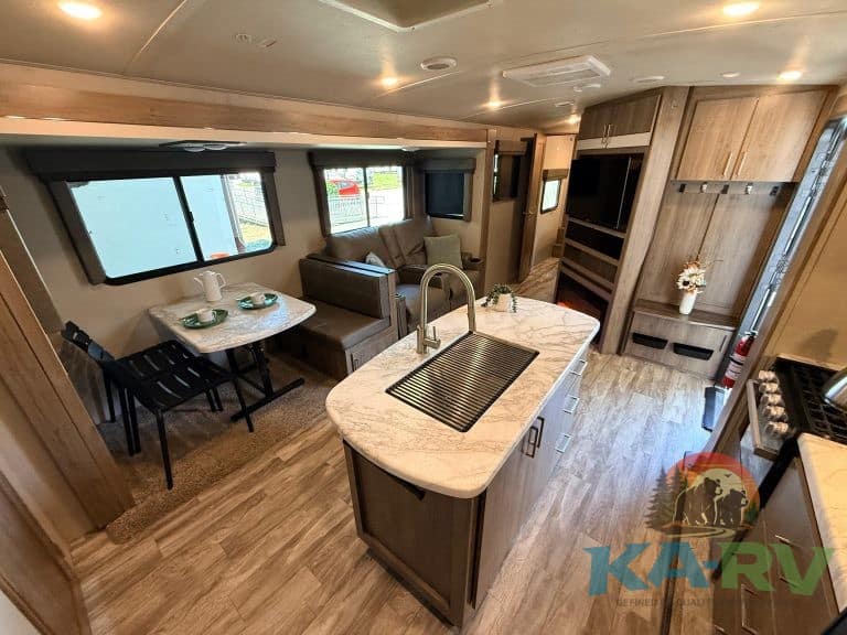 RV interior kitchen and living space with modern amenities and cozy seating, ideal for travel and re.