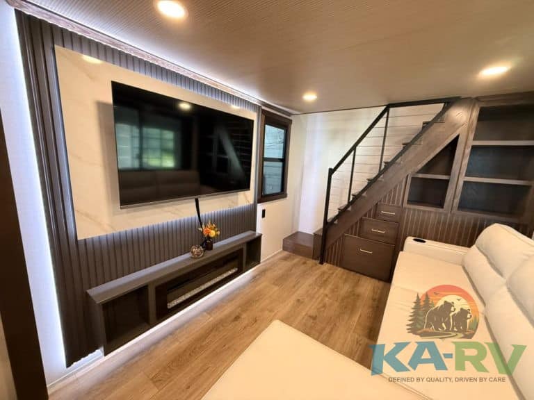 Cozy living room with TV, staircase, and modern decor at Cedar Creek Cottage 41 FWC.