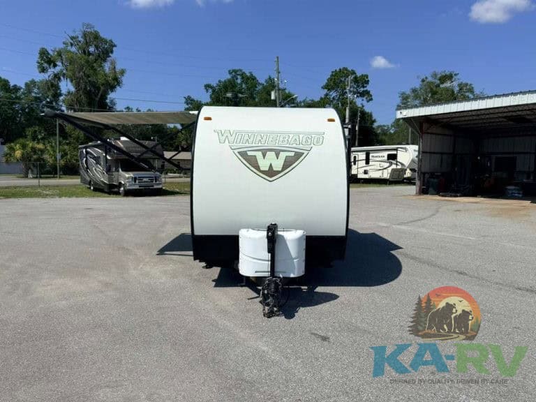 Front view of Winnebago Minnie Drop 1780 travel trailer in lot.