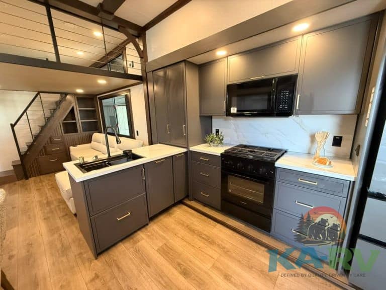 Contemporary kitchen with gray cabinets and black appliances in Cedar Creek Cottage.