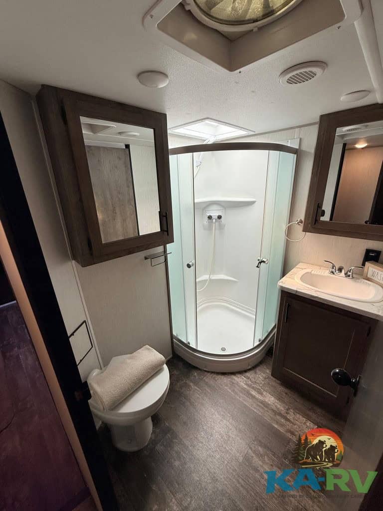 RV bathroom with shower, toilet, and sink in a Forest River Cherokee Wolf Pack 325PACK13.