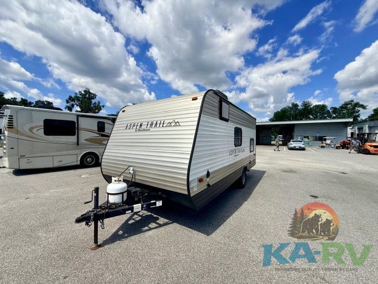 Modern travel trailer parked outdoors, ready for camping adventures.