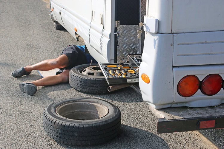 RV tire repair under the RV for safe road trips.