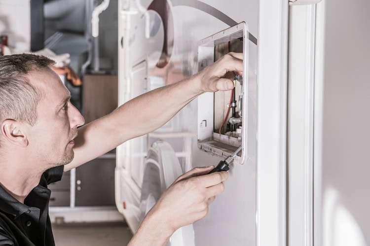 Technician performing maintenance on an RV appliance or system.