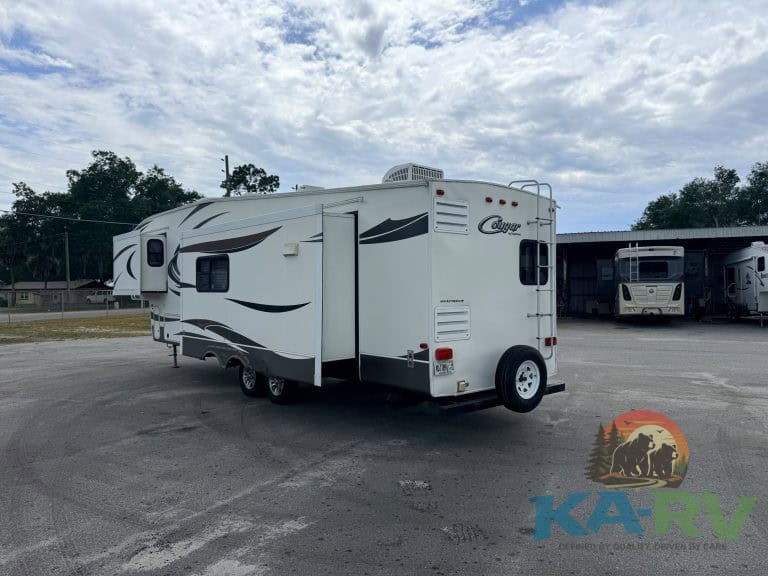 Modern white RV trailer with black accents parked outdoors at Karv Repair.