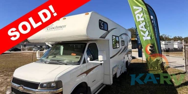 White 2013 Coachmen Freelander RV with sold banner at dealership.