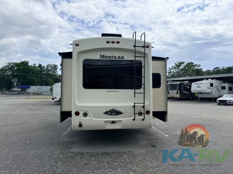 RV Montana trailer with ladder and rear view, parked outdoors at Karv Repair.