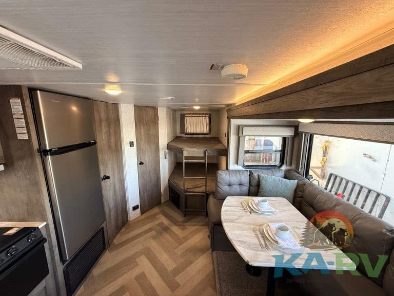 RV interior with cozy dining and sleeping area for optimal comfort.