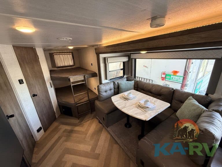 Comfortable RV living space with dining area and bunk beds for family trips.