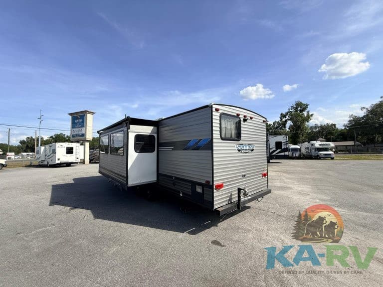 Travel trailer RV for sale at Karv Repair with slide-out and outdoor storage.