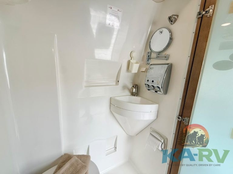 RV bathroom with sink, mirror, and storage compartments at Karv Repair.