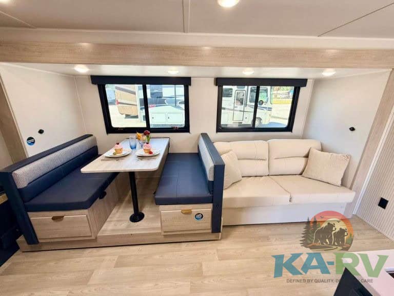 Comfortable RV interior with dining area and sofa in 2026 Acclaim 2700BH.