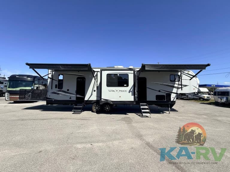 Outdoor view of a 2021 Forest River Cherokee Wolf Pack 325PACK13 RV with extended awnings.