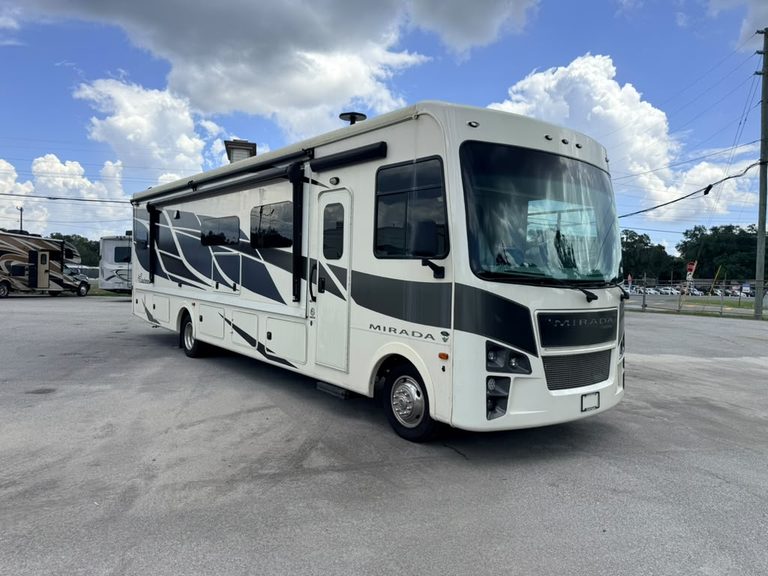 2023 Coachmen Mirada 35OS motorhome parked outdoors under blue sky.