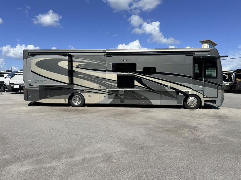 Side view of 2018 Fleetwood Discovery 40X LXE motorhome in parking lot.