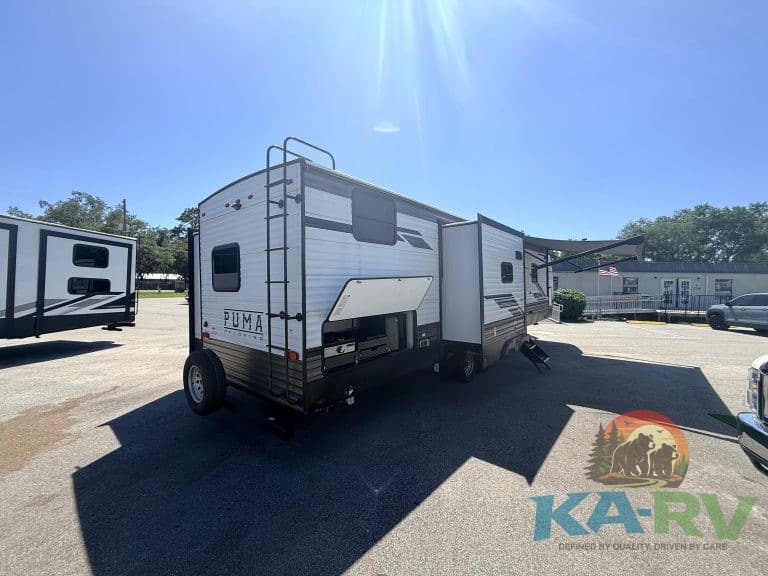 Travel trailer parked outdoors at KA RV Repair for maintenance and repairs.