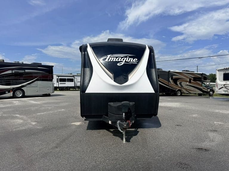 Front view of Imagine travel trailer in RV lot with other RVs.