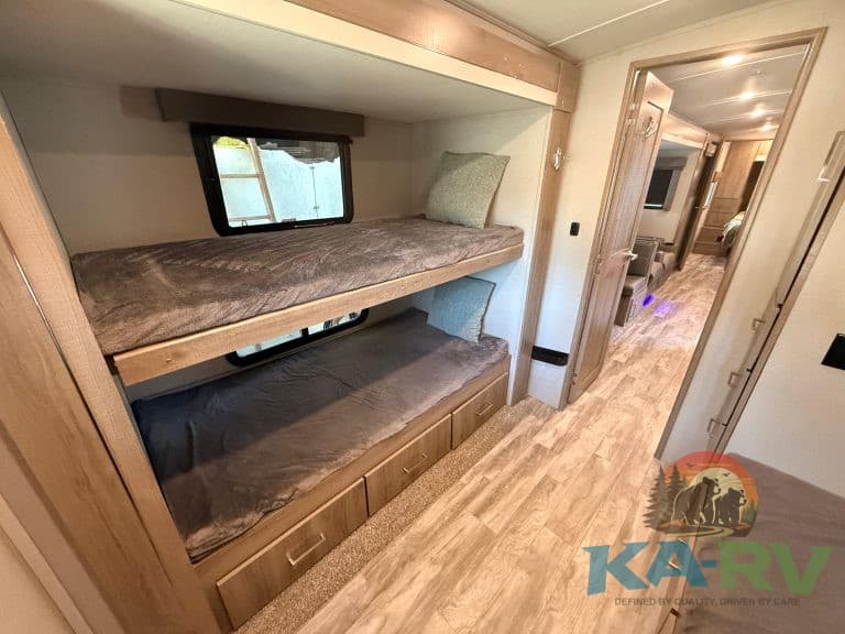 Bunk beds in an RV with storage drawers, ideal for family trips and space-saving travel.