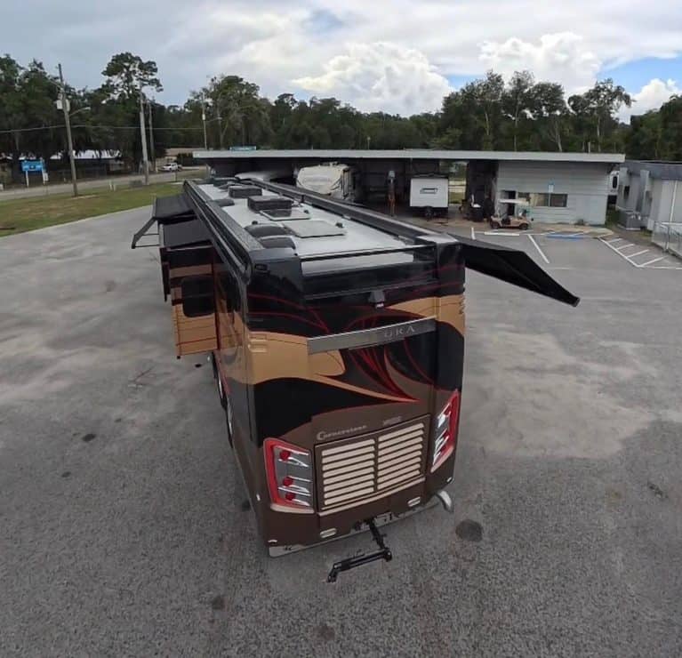 Luxury RV parked outdoors with slide-out extended, showcasing high-end features.