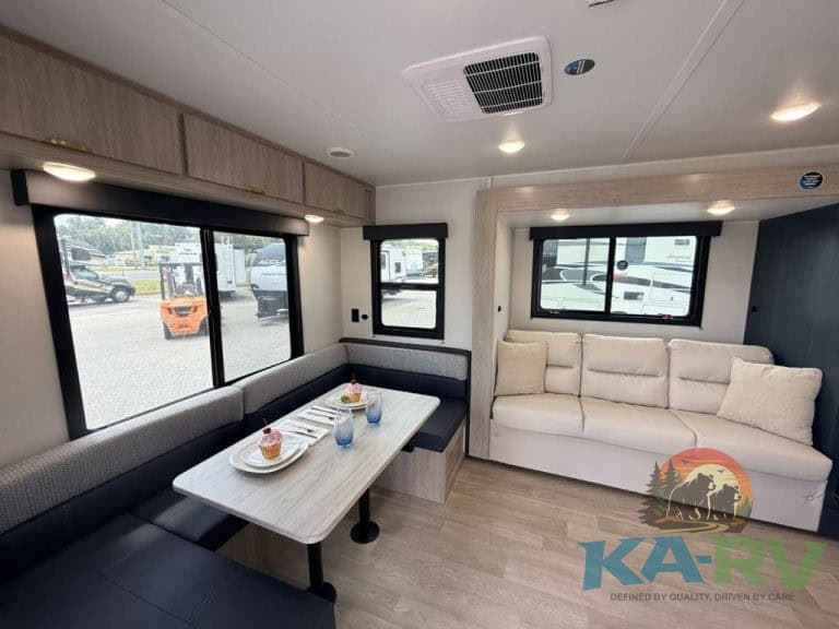 Comfortable RV interior with dining area and sofa in 2026 Acclaim 2500RD.