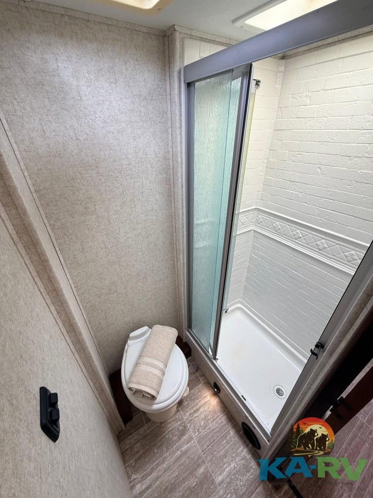Compact RV bathroom with shower and toilet for optimal space utilization.