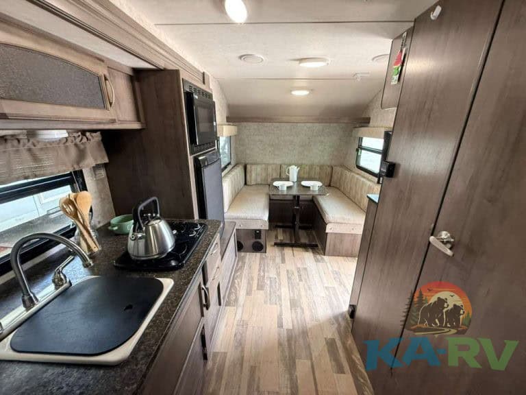 RV interior with kitchen and dining area in a 2017 Winnebago Winnie Drop 1780.
