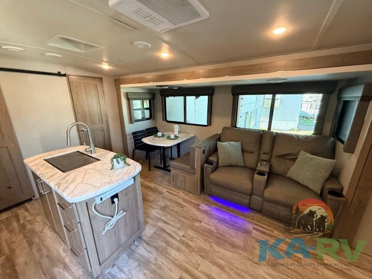 RV interior with cozy sofa, dining nook, and kitchen island for optimal travel comfort.