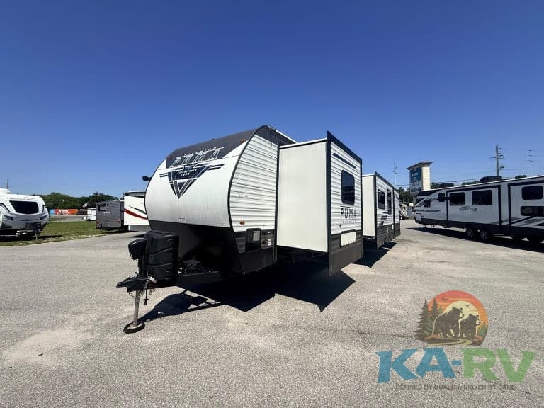 Travel trailer with slide-out at KA RV Repair lot, showcasing RV maintenance and repair services.