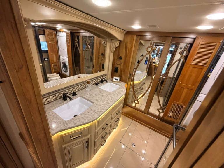 Luxury RV bathroom with dual sinks and elegant wood accents.