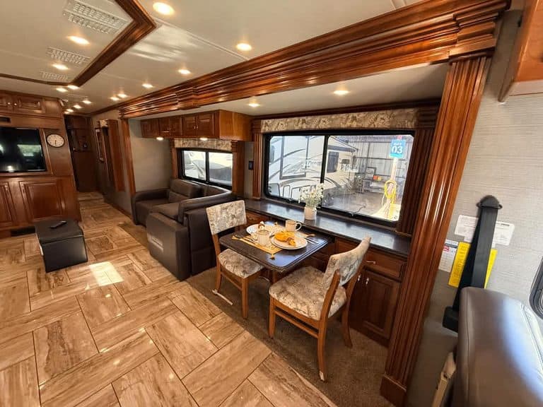 Elegant RV interior with dining table and plush seating for travel comfort.