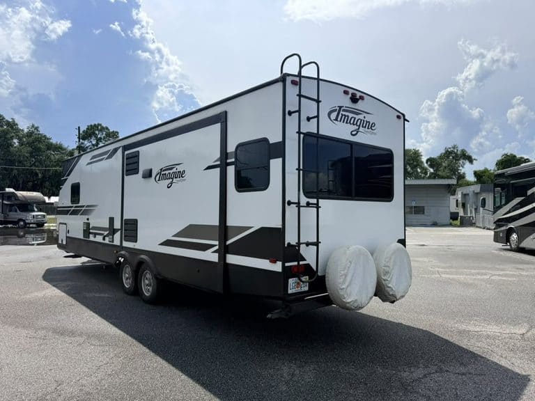Travel trailer with spare tires and ladder at KA RV Repair.