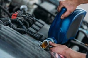 Engine oil top-up for RV engine maintenance.