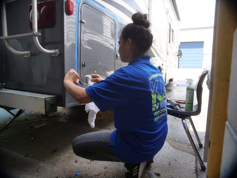 A KA RV employee works on the rear of an RV. Having access to our expert RV service team is a reason to consign your RV