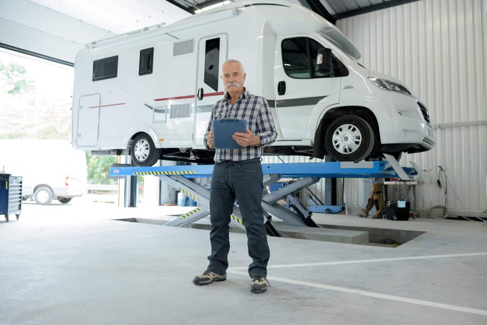 RV repair technician inspecting a motorhome during spring maintenance.